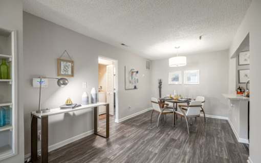 A dining room with a table set for four.