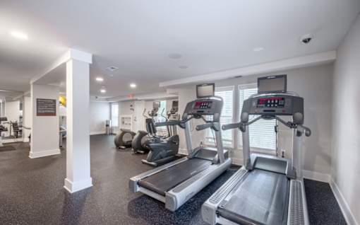 A gym with treadmills and elliptical machines.
