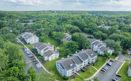 A bird's eye view of a residential area with houses and parked cars.