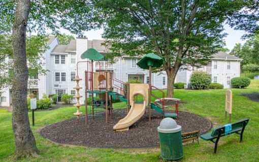 A playground with a slide, swings, and a climbing frame.