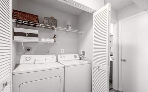 A white laundry room with a washer and dryer.