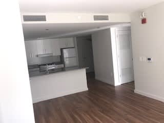A kitchen with white cabinets and a wooden floor.