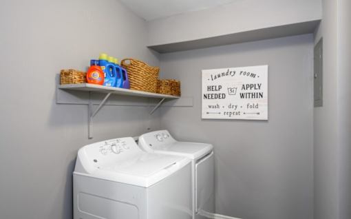A laundry room with a sign that says "Help Apply Within".