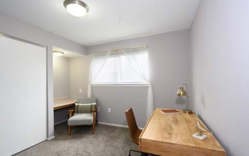 A room with a desk and chairs.