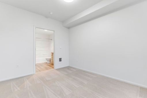 A room with a white door and a light on the wall.