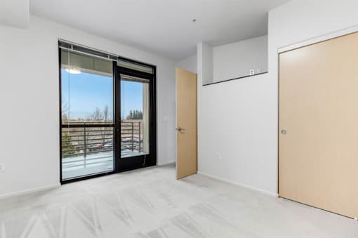A room with a sliding glass door and a wooden door.