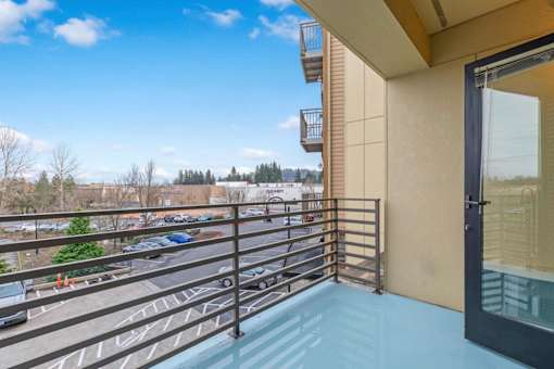 A balcony with a metal railing and a glass door.