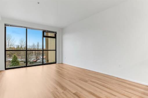 A room with a large window and wooden flooring.