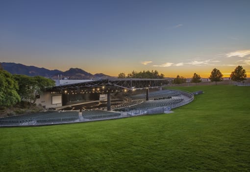 a view of a stadium at sunset with mountains in the background