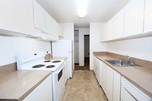 A kitchen with white appliances and cabinets.