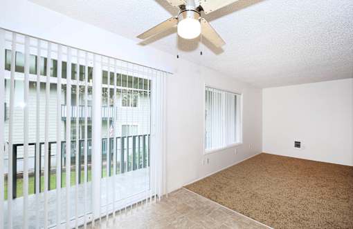 A room with a ceiling fan and a carpeted floor.