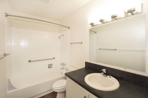A bathroom with a toilet, sink, and shower.