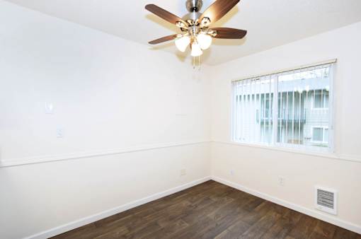 A room with a ceiling fan and a window.