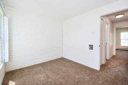 an empty living room with white walls and a carpeted floor