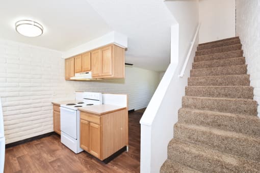a kitchen with a stove and a staircase in a house