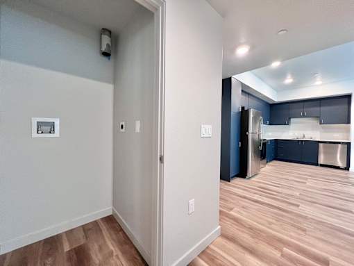 A kitchen with a refrigerator, cabinets, and a countertop.
