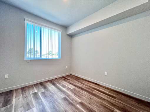 A room with a window and wooden flooring.