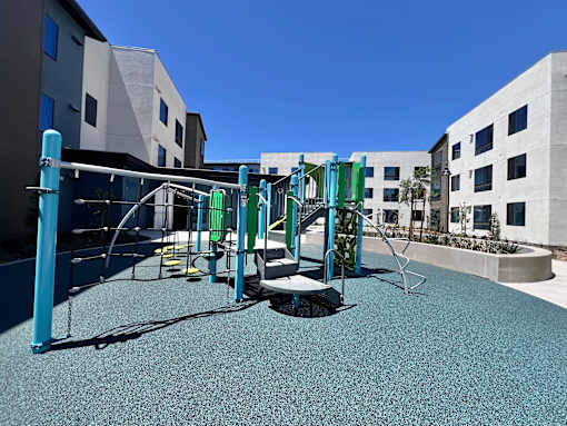 A playground with a blue and green swing set.
