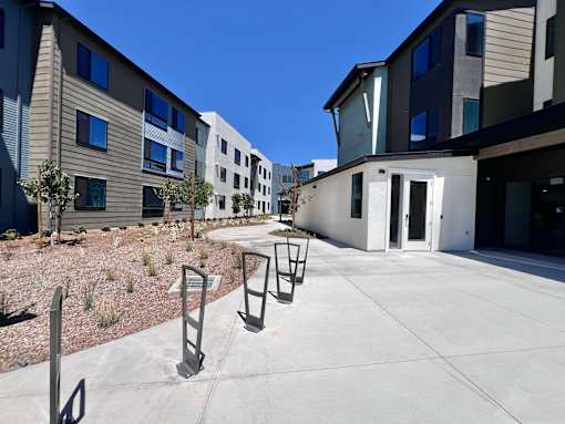 A sunny day at a modern apartment complex with a clear blue sky.