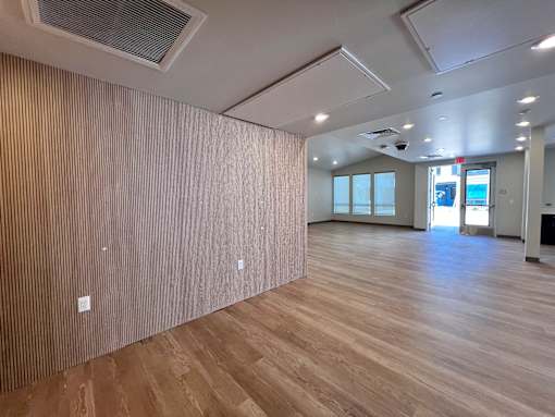 A room with wooden flooring and a wall covered in wood paneling.