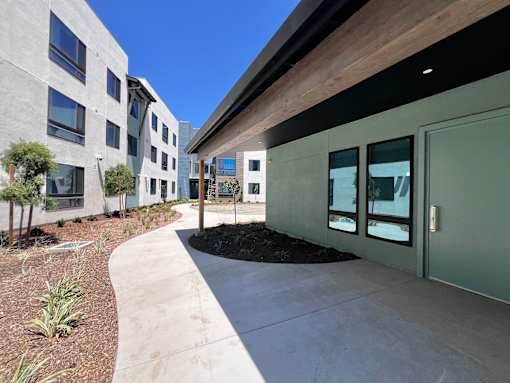 A modern building with a concrete walkway in front.