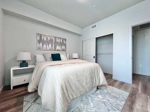 A bedroom with a large bed and a painting above it.
