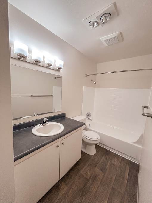 A bathroom with a sink, toilet, and bathtub.