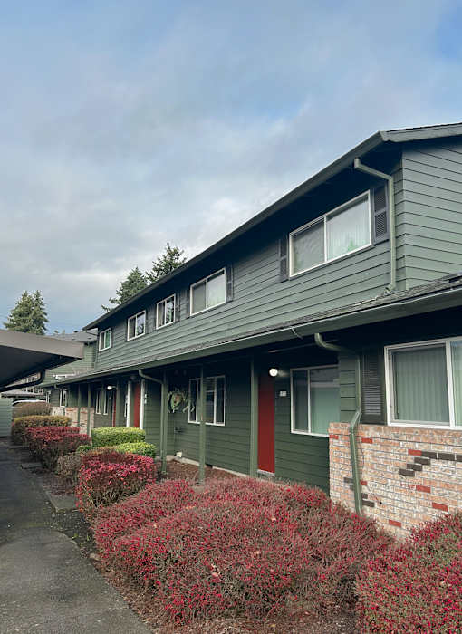 A green building with red doors and windows.