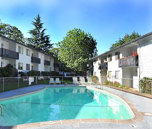 a large swimming pool in front of an apartment building