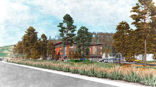 A road with a building and trees on the side.