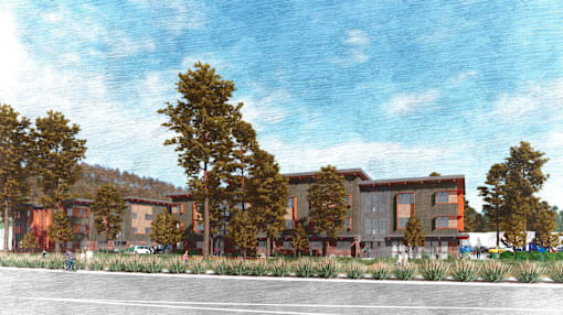 A building with orange and brown colors is surrounded by trees.