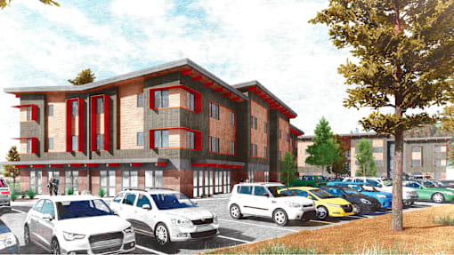 A row of cars are parked in front of a red and white building.