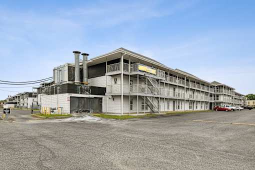 A large, multi-story building with a parking lot in front.