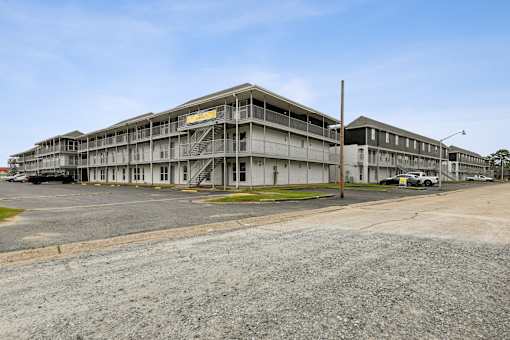 A large, multi-story building with a parking lot in front.