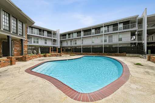 A swimming pool in a courtyard surrounded by buildings.