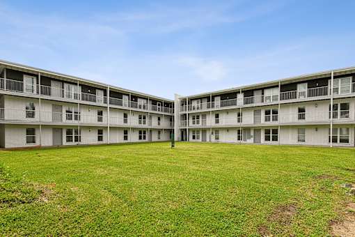 A large grassy area in front of apartment buildings.