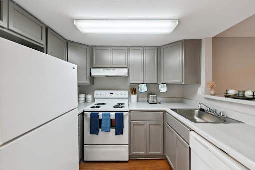 A kitchen with a white refrigerator and a white stove.