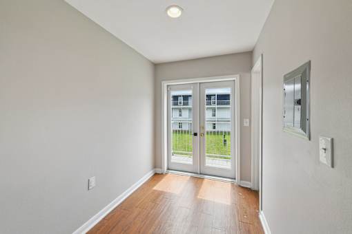 A room with a sliding glass door leading to a balcony.