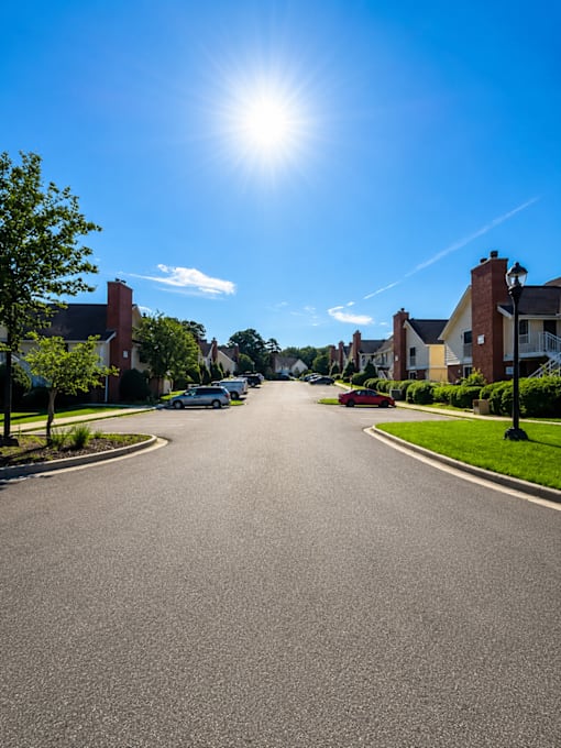 A sunny day on a residential street with houses on both sides.