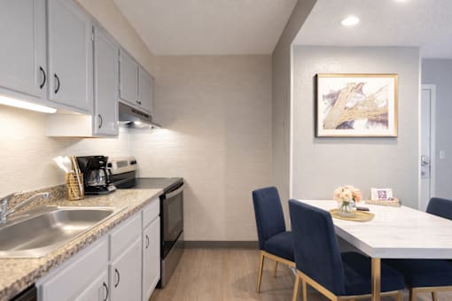 A kitchen with a table and chairs.