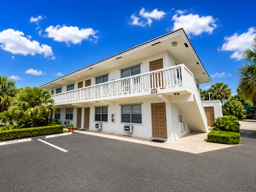 459 - A white two-story building with a balcony on the second floor.