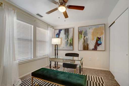 A room with a green bench and a painting on the wall.