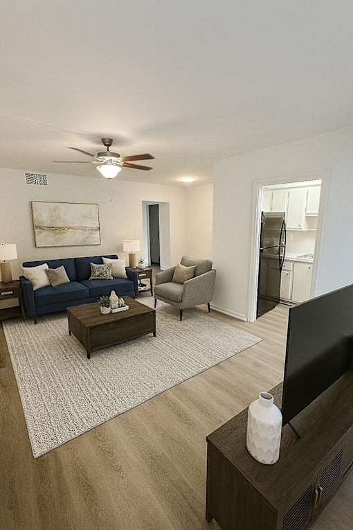 A living room with a blue couch, a coffee table, and a television.
