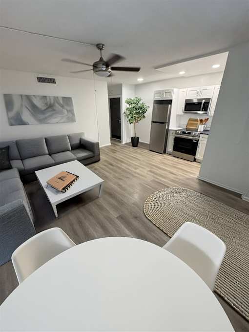 A modern living room with a grey couch and a white coffee table.