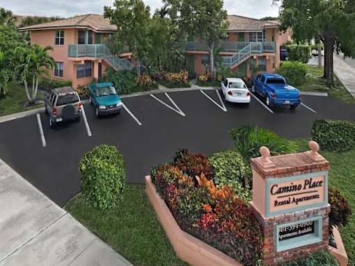 Cars parked in a parking lot in front of a building with a sign that says Cemino Place Rental Apartments.