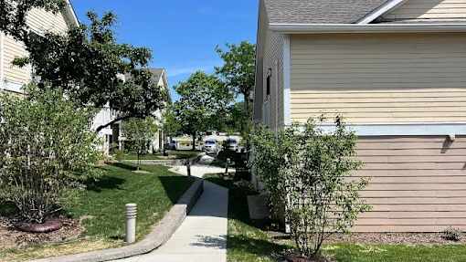 A residential street with houses on both sides and a sidewalk.