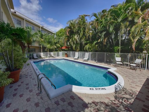 a swimming pool at a hotel with palm trees