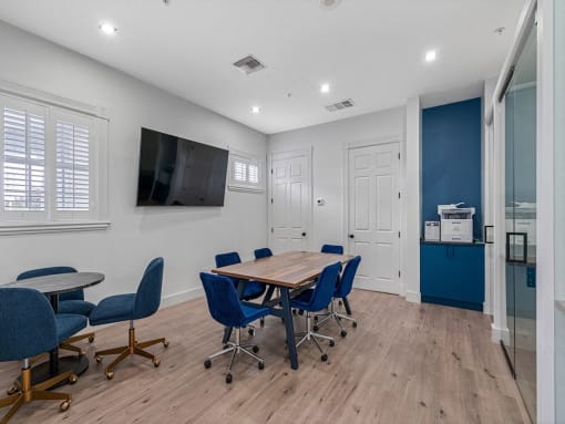 a conference room with a table and chairs and a tv