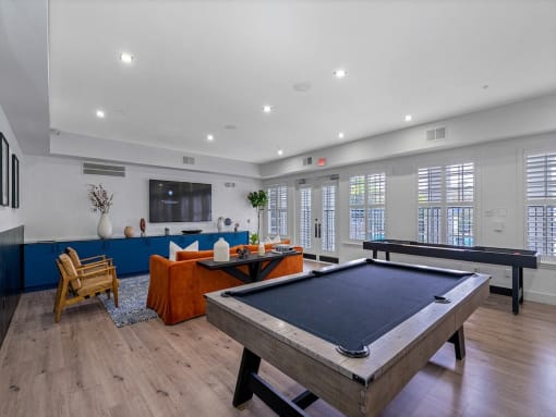 a game room with a pool table and a television