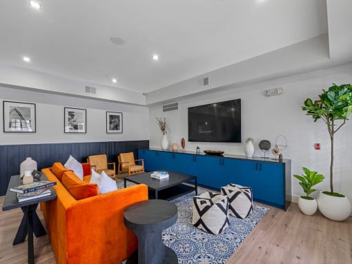 a living room with a blue and orange couch and a television